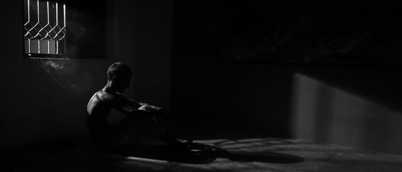 A founder sitting alone in a dark room lit by a window